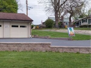Residential retaining wall installed along a driveway and lawn