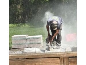 Contractor cutting stone during an outdoor hardscaping project