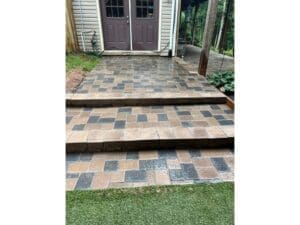 Paver patio landing with steps leading to a back door